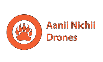 A logo for the company Aanii Nichii Drones. The logo has a thick orange circle with a transparent middle. In the middle of the circle is an orange bear paw. To the right of the bear paw is the company name, Aanii Nichii Drones, in orange.